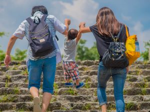 子どもと一緒に階段を上がる夫婦